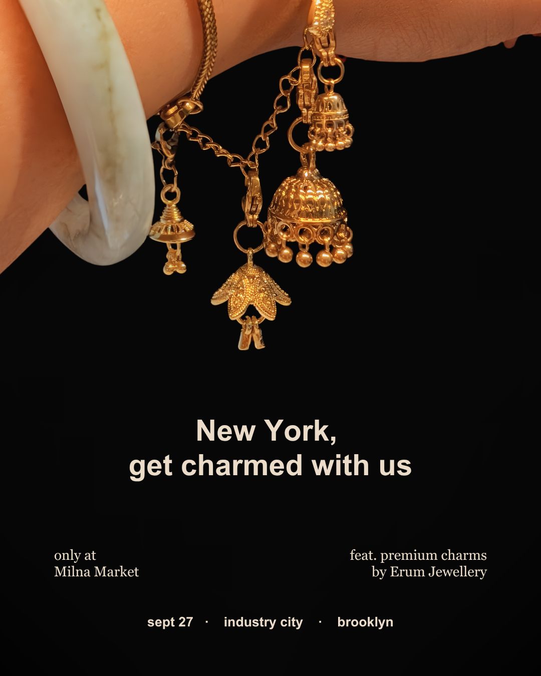 Gold jhumka charms on a bangle with the words New York, get charmed with us, only at Milna Market